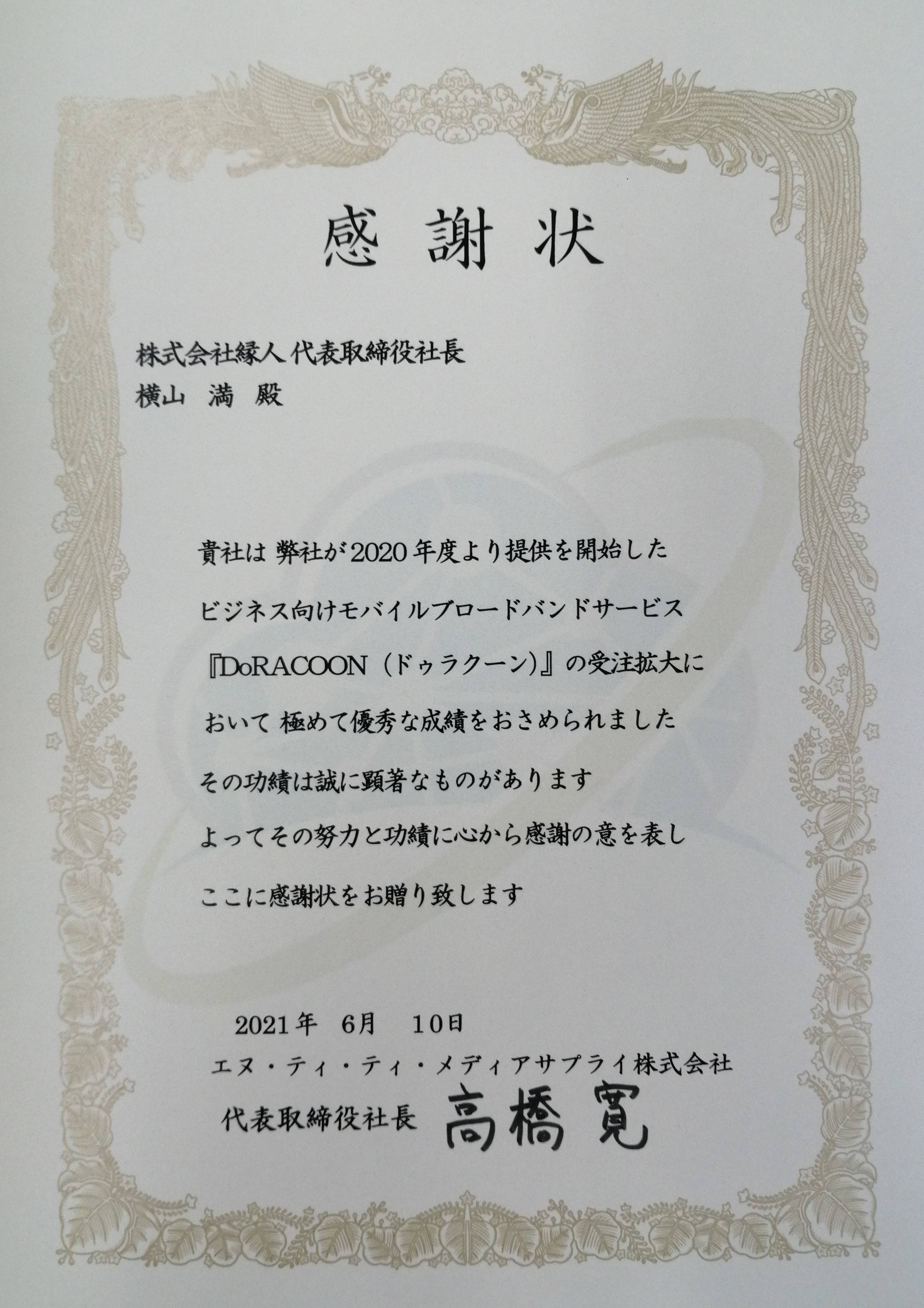 感謝状　株式会社縁人代表取締役社長横山満殿　貴社は弊社が2020年度より提供を開始したビジネス向けモバイルブロードバンドサービス「DoRACOON（ドゥラクーン）」の受注拡大において極めて優秀な成績をおさめられました その功績は誠に顕著なものがあります よってその努力と功績に心から感謝の意を表しここに感謝状をお贈り致します 2021年6月10日 エヌ・ティ・ティ・メディアサプライ株式会社 代表取締役社長高橋寛