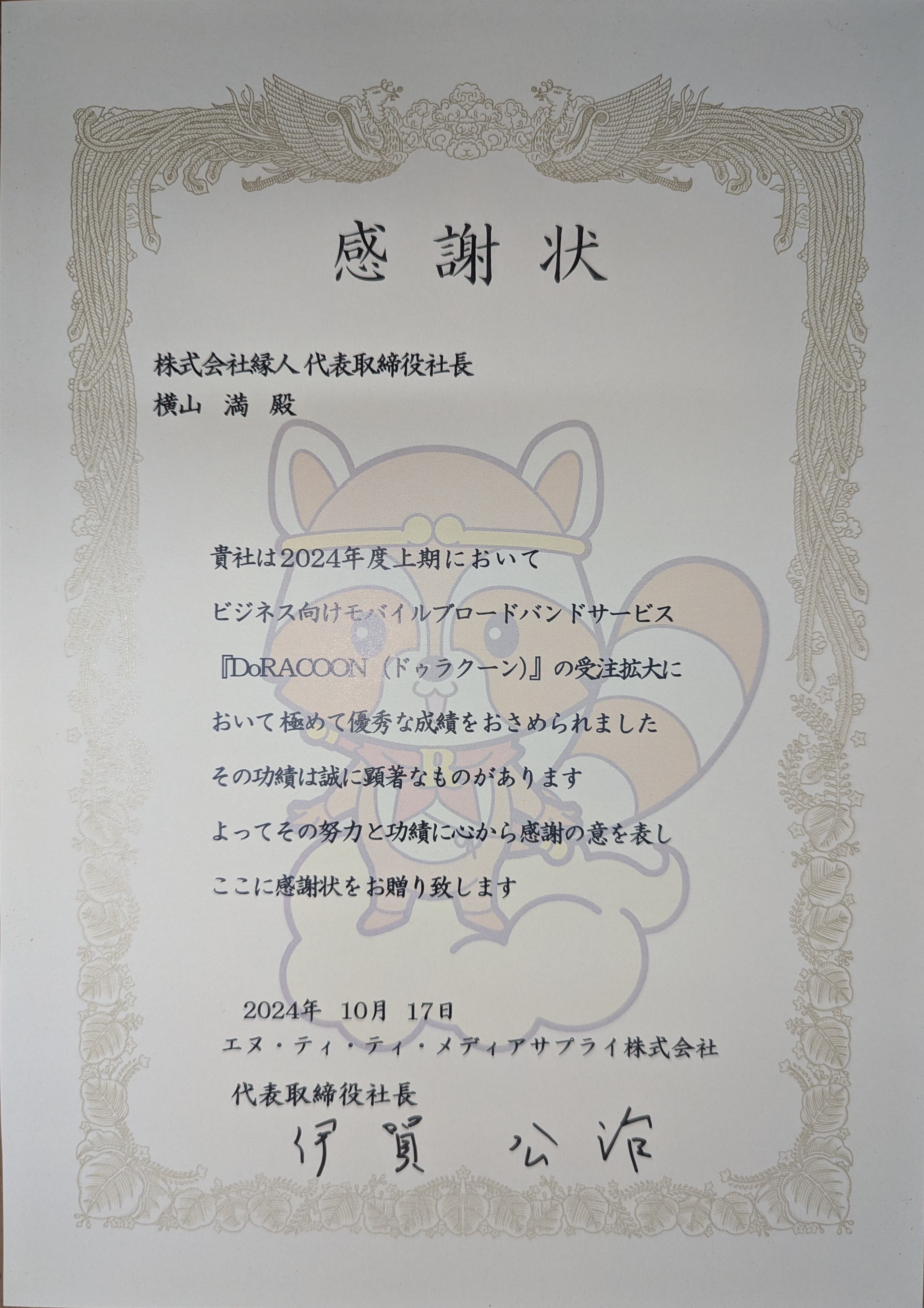 感謝状　株式会社縁人代表取締役社長横山満殿　貴社は2024年度上期においてビジネス向けモバイルブロードバンドサービス「DoRACOON（ドゥラクーン）」の受注拡大において極めて優秀な成績をおさめられました その功績は誠に顕著なものがあります よってその努力と功績に心から感謝の意を表しここに感謝状をお贈り致します 2024年10月17日 エヌ・ティ・ティ・メディアサプライ株式会社 代表取締役社長伊賀公治